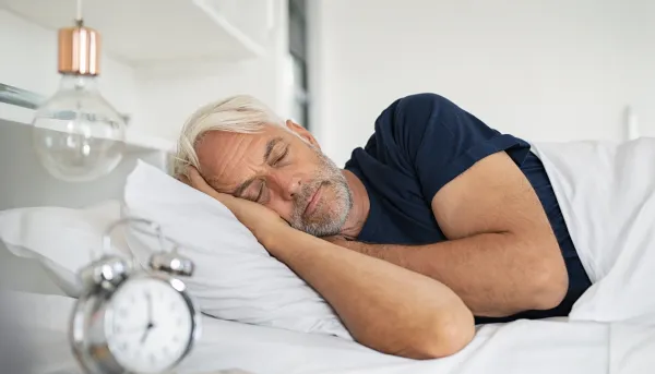 Älterer Mann schläft in seinem Bett.